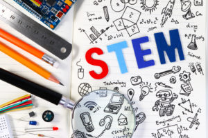 STEM education. Science Technology Engineering Mathematics. STEM concept with drawing background. Hand with pencil writing on education background.